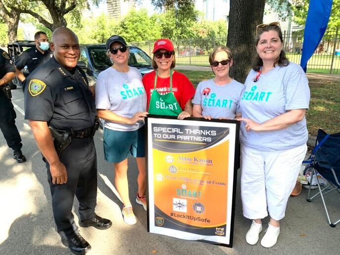 Members of Be SMART and a police officer pose with a thank you sign.