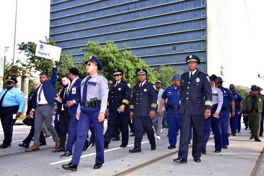 Members of N.O.B.L.E. walk in a group down the street